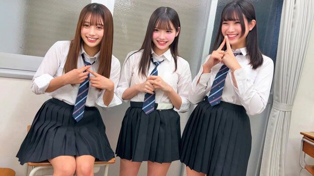 制服姿の女子3人が並び、ネクタイや口元に手を添えて笑顔で男子を見つめる