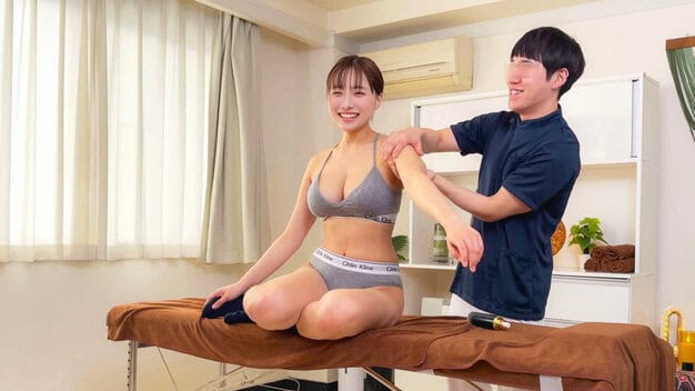 女性は笑いながら座っている　男性は女性の左肩を触っている