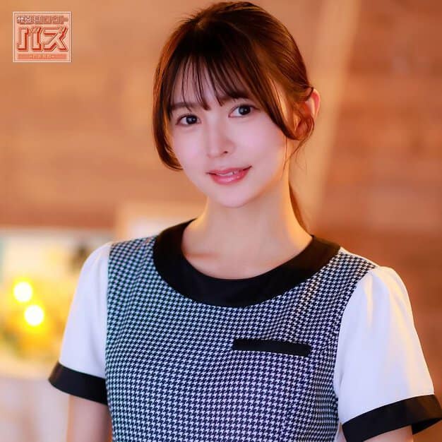 千鳥格子柄の制服を着た女性が穏やかな表情でカメラを見ている。