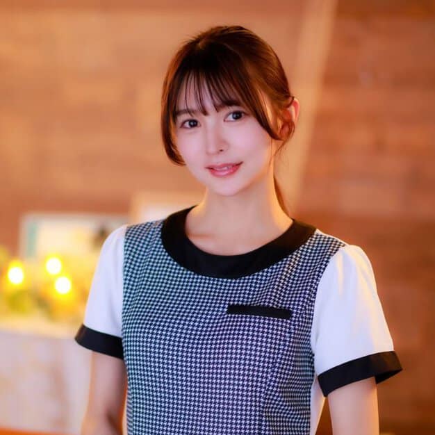 千鳥格子柄の制服を着た女性が口角を上げて微笑んでいる。